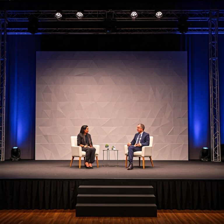A,Conference,Stage,With,Two,Chairs,,One,Person,Sitting,In
